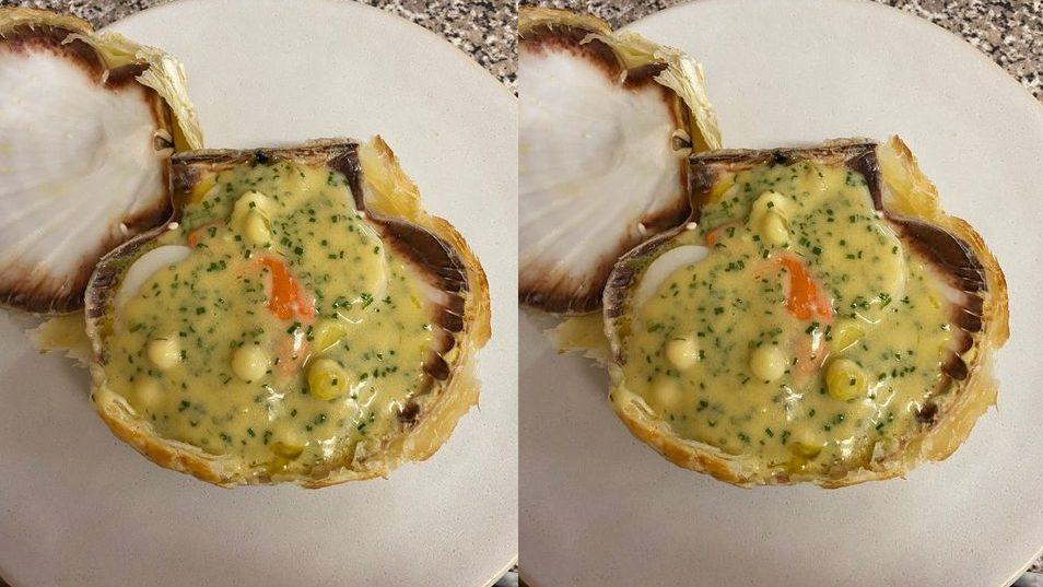 Baked scallop in the shell with buttered leeks, cider and apple